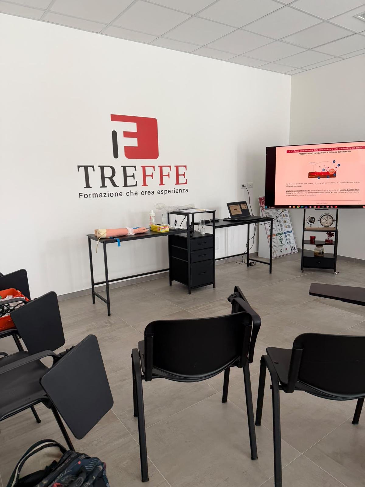 Aula treffe con logo a parete e schermo per le lezioni
